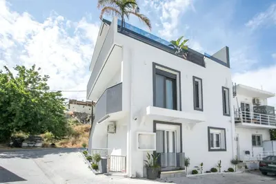 a white house with a palm tree on top at Casa Antonis - Modern Home with Jacuzzi near Faliraki in Kalithies