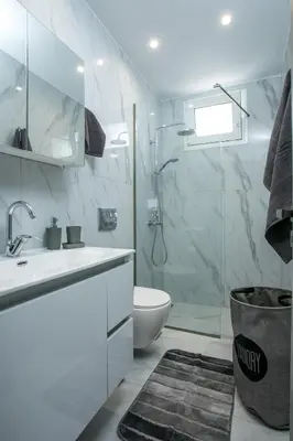 a bathroom with a sink and a toilet and a shower at Casa Antonis - Modern Home with Jacuzzi near Faliraki in Kalithies