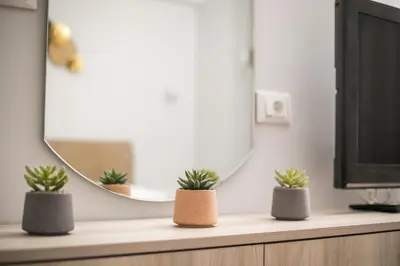 a desk with three potted plants and a mirror at Casa Antonis - Modern Home with Jacuzzi near Faliraki in Kalithies