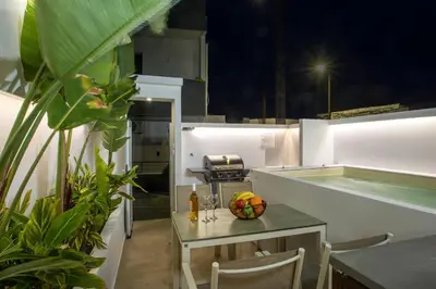 a kitchen with a table with a bowl of fruit on it at Casa Antonis - Modern Home with Jacuzzi near Faliraki in Kalithies