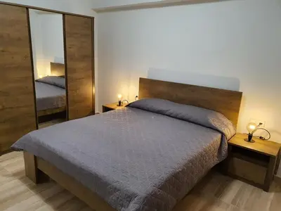 a bedroom with a bed and a large mirror at Perama View Apartments in Eleoúsa