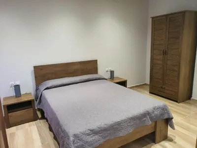a bedroom with a bed and a wooden cabinet at Perama View Apartments in Eleoúsa