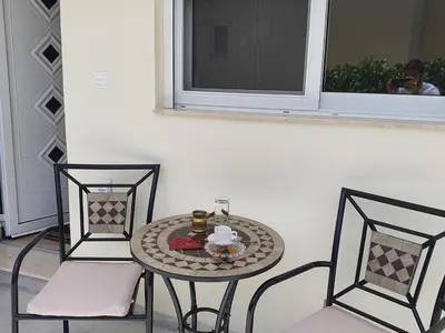 a table and two chairs with a table and a window at Perama View Apartments in Eleoúsa