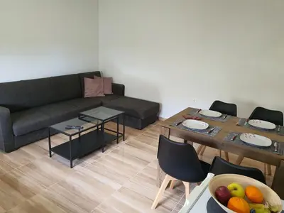 a living room with a couch and a table with a bowl of fruit at Perama View Apartments in Eleoúsa