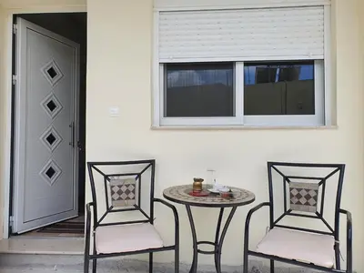 two chairs and a table and a window at Perama View Apartments in Eleoúsa