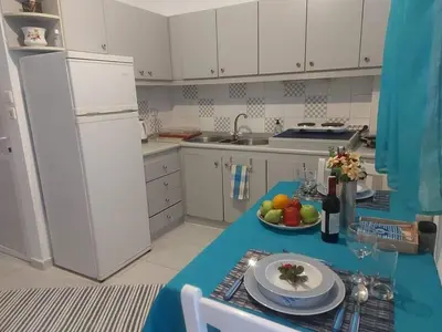 a kitchen with a table with a plate of fruit on it at Jaana & Akis Holiday Home 1&2, Haraki in Haraki