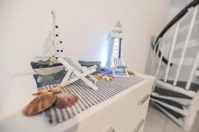 a shelf with two chairs and a model boat on it at Jaana & Akis Holiday Home 1&2, Haraki in Haraki
