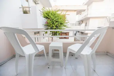 a white table and two chairs on a balcony at Jaana & Akis Holiday Home 1&2, Haraki in Haraki