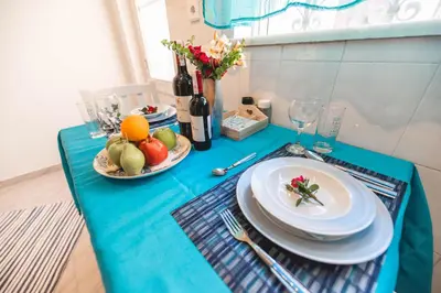 a blue table with plates of fruit and wine bottles at Jaana & Akis Holiday Home 1&2, Haraki in Haraki