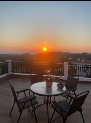 a table and chairs on a balcony with a sunset at Seaview Villa - Amazing Sea & Mountain View in Koskinou