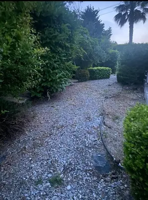 a garden with a hose laying on the ground at Seaview Villa - Amazing Sea & Mountain View in Koskinou