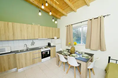 a kitchen with a table and chairs in a room at Jimmy's Pool House in Kremasti