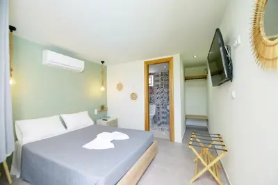 a bedroom with a bed and a flat screen tv at Jimmy's Pool House in Kremasti