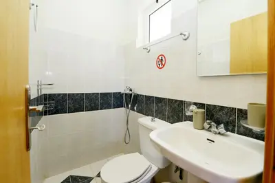 a bathroom with a toilet and a sink at Jimmy's Pool House in Kremasti