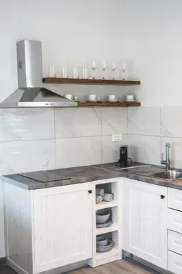a kitchen with white cabinets and a sink at Aesthisis Sensational Accommodation in Kolimbia