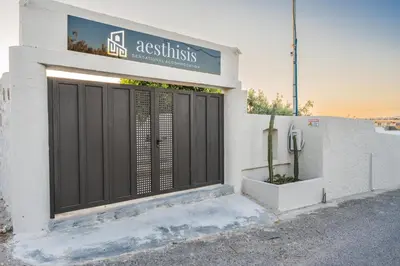 a white building with a black door and a cactus at Aesthisis Sensational Accommodation in Kolimbia