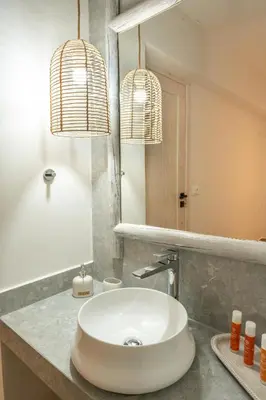 a bathroom with a sink and two pendant lights at Aesthisis Sensational Accommodation in Kolimbia