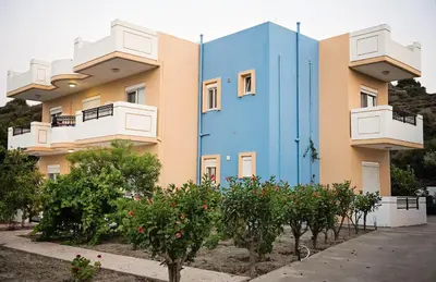 a colorful building with trees in front of it at Nephele Apartments in Faliraki