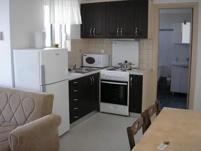 a kitchen with a white refrigerator and a stove at Nephele Apartments in Faliraki