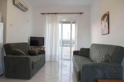 a living room with a couch and a chair at Nephele Apartments in Faliraki