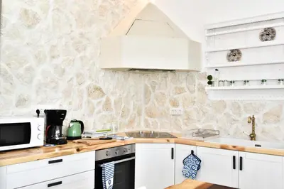 a kitchen with white cabinets and a microwave at Villa Despina in Afantou