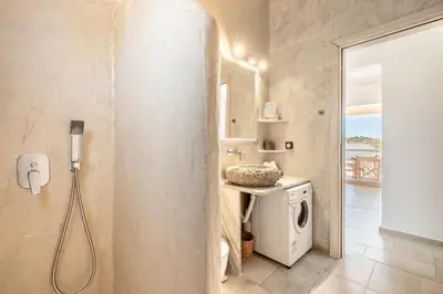 a bathroom with a sink and a washing machine at Villa Despina in Afantou