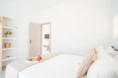 a white bed with a bowl of toys on it at Villa Despina in Afantou