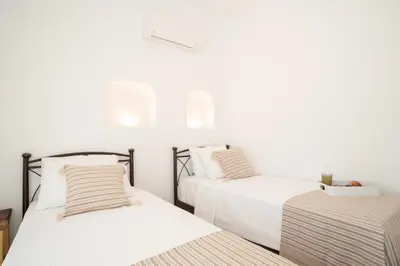 two beds in a room with white walls at Villa Despina in Afantou