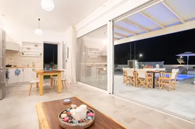 a kitchen and living room with a large sliding glass door at Villa Despina in Afantou