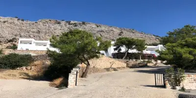 a road with trees and houses on a mountain at Karpathios Studios Pefkos in Pefki Rhodes