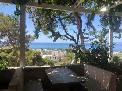 a view of the ocean from a porch with a bench at Karpathios Studios Pefkos in Pefki Rhodes