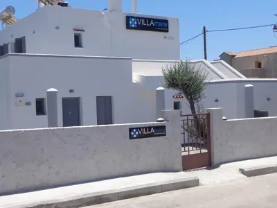 a white building with a gate and a fence at Villa Mare by Delfinia Resort in Kolimbia