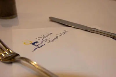 a piece of paper with a fork and knife on a table at Villa Mare by Delfinia Resort in Kolimbia