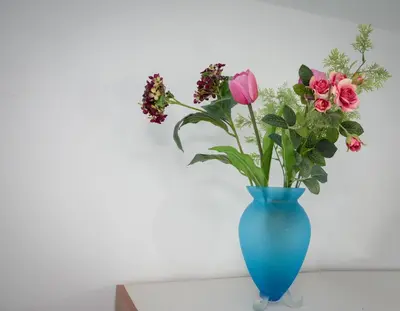 a blue vase filled with flowers on a table at Daisy's room in Archangelos