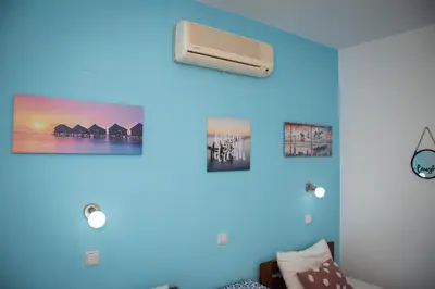 a room with a blue wall with a air conditioner at Daisy's room in Archangelos