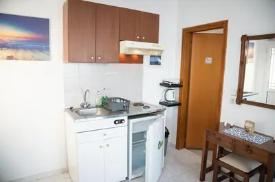 a small kitchen with a sink and a stove at Daisy's room in Archangelos