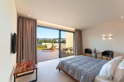 a bedroom with a bed and a view of a patio at Aethrion Villas & Suites in Gennadi