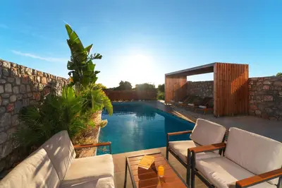 a swimming pool with two couches and a patio at Aethrion Villas & Suites in Gennadi