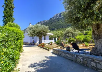 a house with two chairs sitting in a yard at Villa Bella Montagna in Kapíon