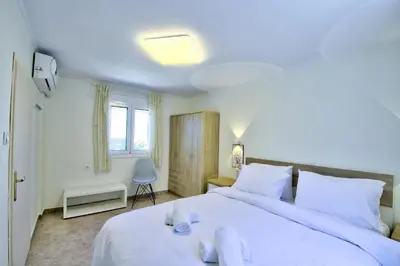 a bedroom with a large white bed with towels on it at Villa Bella Montagna in Kapíon