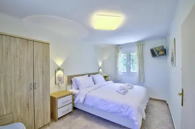 a bedroom with a white bed with a teddy bear on it at Villa Bella Montagna in Kapíon