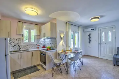 a kitchen with a table and chairs in it at Villa Bella Montagna in Kapíon