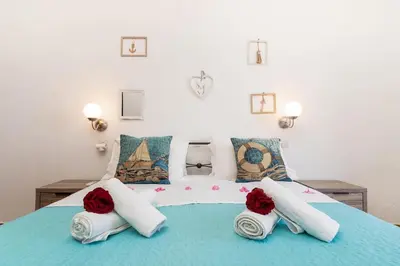 a bedroom with a bed with two roses on it at Gennadi Sun Apartments 500m from the beach in Gennadi