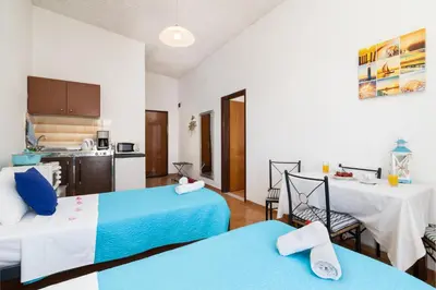 a living room with two beds and a kitchen at Gennadi Sun Apartments 500m from the beach in Gennadi