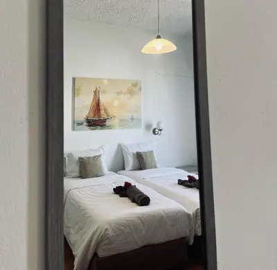 a mirror reflecting two beds in a room at Gennadi Sun Apartments 500m from the beach in Gennadi