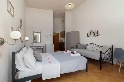 a bedroom with two beds with white sheets at Gennadi Sun Apartments 500m from the beach in Gennadi