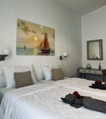 a bedroom with two beds and a painting on the wall at Gennadi Sun Apartments 500m from the beach in Gennadi