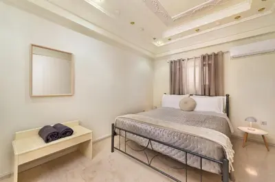 a white bedroom with a bed and a mirror at Mikaela's Pool House in Afantou