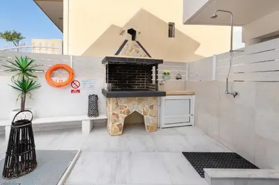 a outdoor kitchen with a stone fireplace in a house at Mikaela's Pool House in Afantou