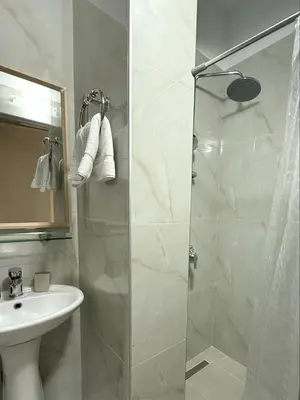 a bathroom with a shower and a sink at Mikaela's Pool House in Afantou
